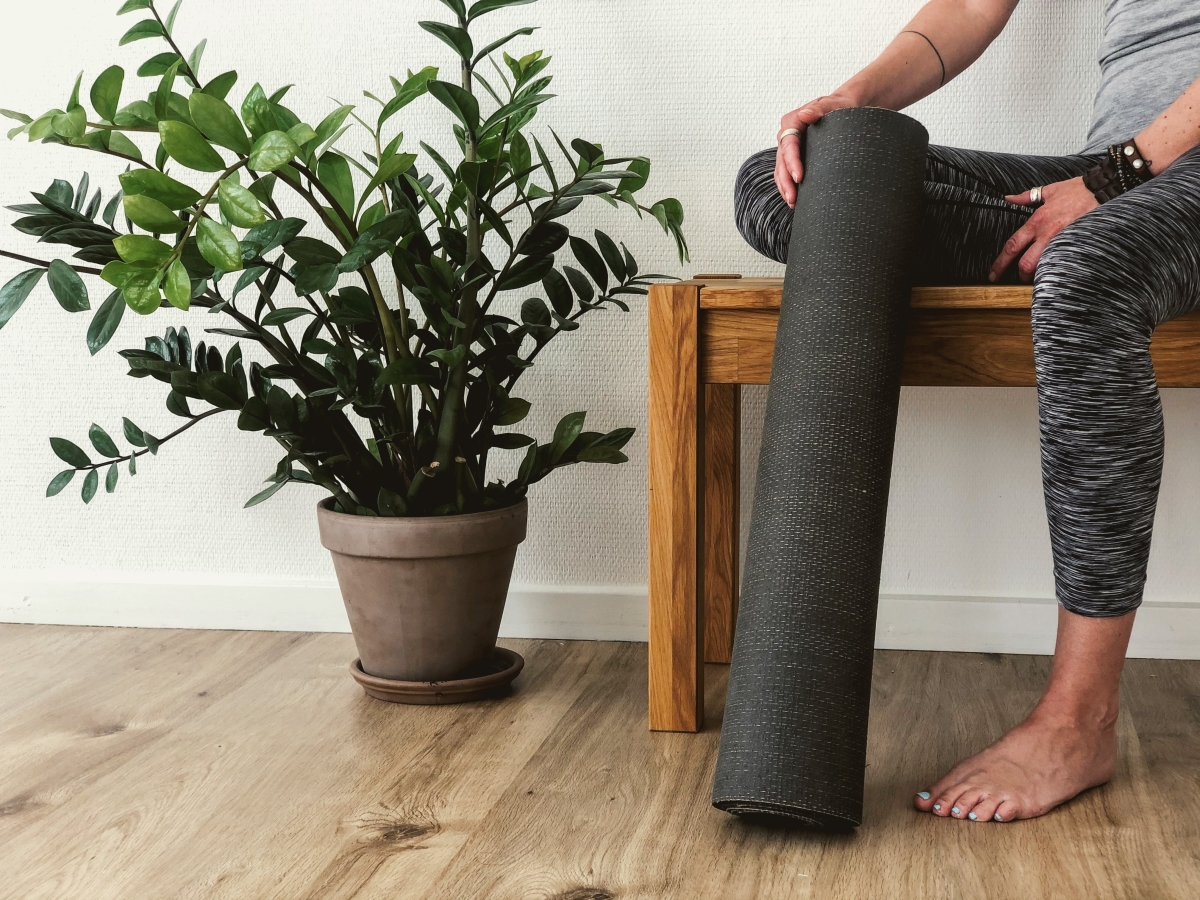 person sitting with yoga mat