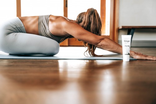 woman in gray sports bra and gray leggings performing stretches for back pain relief