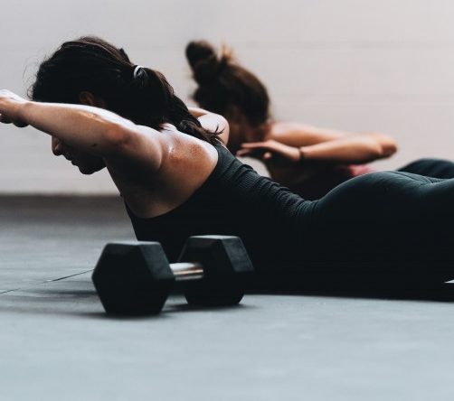 woman lying on her belly and doing back exercise